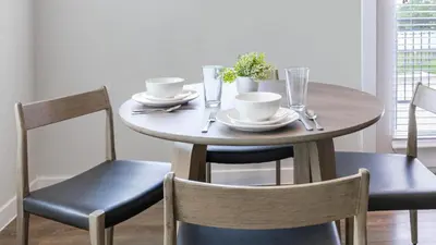 a wooden table with two chairs and a table with cups at Landing Apartments - Park South in Albany