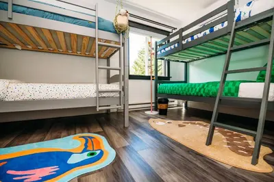 a room with bunk beds and a rug on the floor at Creekside Family Dreamland - Hot Tub, Firepit, Arcade in Pocono Summit