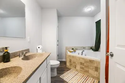 a bathroom with two sinks and a tub and a toilet at Spacious Vacation Home Tobyhanna Gym BBQ Boat in Pocono Country Place