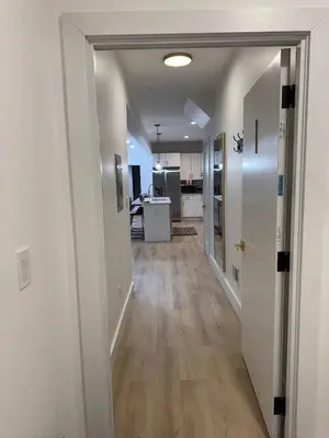 a hallway leading to a room with a kitchen at Modern 3BR Home | Chic & Cozy | 30 Min NYC Access in Jersey City