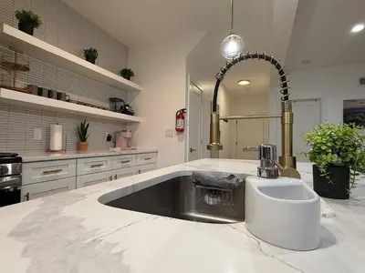 a kitchen with a sink and a large mirror at Modern 3BR Home | Chic & Cozy | 30 Min NYC Access in Jersey City