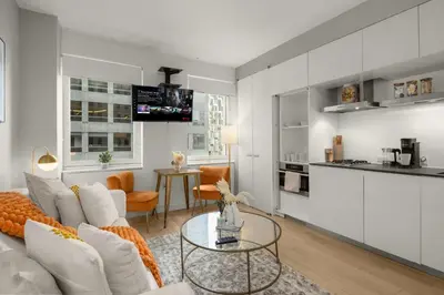 a living room and kitchen with a couch and a table at Chic NYC Retreat Beside Broadway in New York