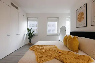 a bedroom with a bed with a blanket on it at Elegant NYC Haven Walk to Broadway in New York