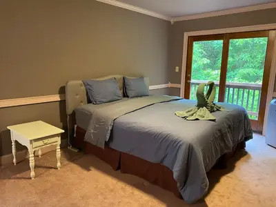 a bedroom with two beds and a large window at Saratoga Lake Boathouse Retreat in Saratoga Springs