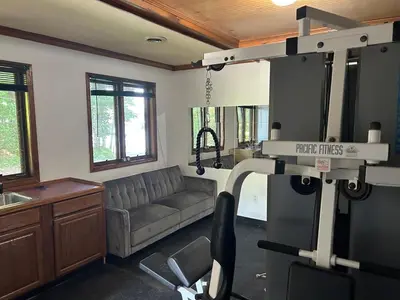 a living room with a couch and a gym at Saratoga Lake Boathouse Retreat in Saratoga Springs