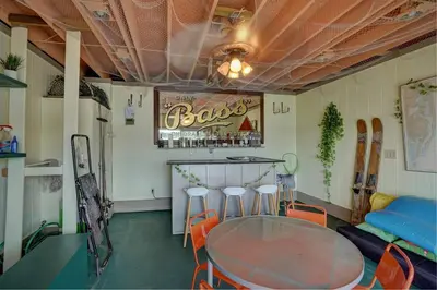 a table and chairs in a room with a bar at Saratoga Lake Boathouse Retreat in Saratoga Springs
