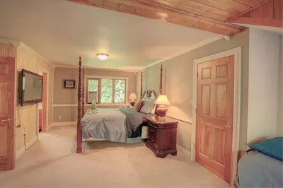 a bedroom with a bed and a window at Saratoga Lake Boathouse Retreat in Saratoga Springs