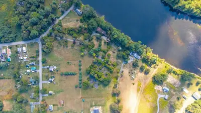 an aerial view of a group of houses next to a river at Governors Mansion on the Hudson - Saratoga Riverside Estate in Greenwich