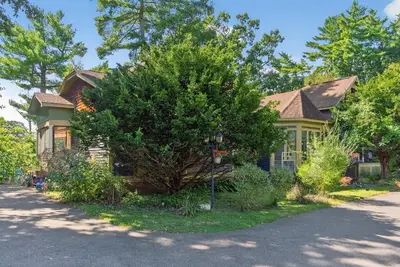 a house with a tree in front of a street at Governors Mansion on the Hudson - Saratoga Riverside Estate in Greenwich