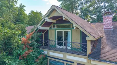 a house with a balcony with a dog on the porch at Governors Mansion on the Hudson - Saratoga Riverside Estate in Greenwich