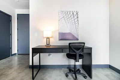 a black desk with a chair and a lamp at Landing Beautiful 1BD Gym in Hartford