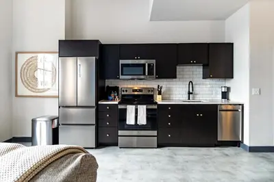 a kitchen with black cabinets and stainless steel appliances at Landing Beautiful 1BD Gym in Hartford
