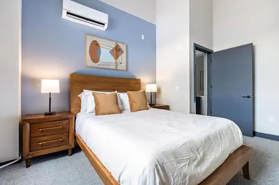 a bedroom with a large bed and a blue wall at Landing Beautiful 1BD Gym in Hartford