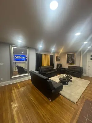 a living room with black furniture and a large window at Newly Renovated Single Family Home in Springfield