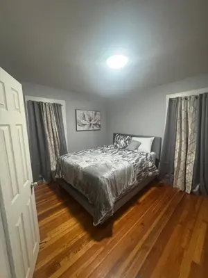 a bedroom with a bed and a wooden floor at Newly Renovated Single Family Home in Springfield