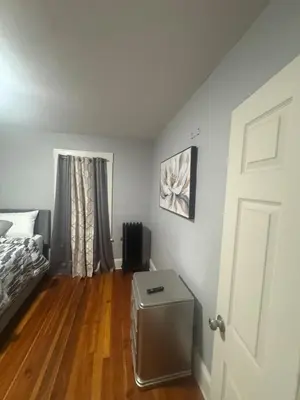 a bedroom with a bed and a wooden floor at Newly Renovated Single Family Home in Springfield