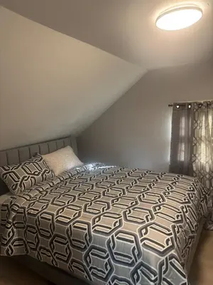 a bedroom with a bed with a black and white comforter at Newly Renovated Single Family Home in Springfield