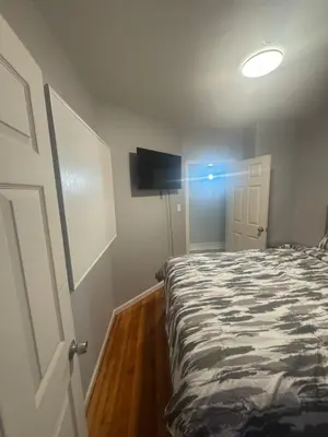 a bedroom with a bed and a tv on the wall at Newly Renovated Single Family Home in Springfield