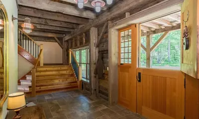 a hallway of a cabin with a wooden door and stairs at Moonrise Rest A Historic Mohawk Valley Retreat in Schenectady