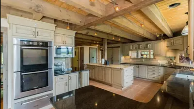 a large kitchen with white cabinets and a wooden ceiling at Moonrise Rest A Historic Mohawk Valley Retreat in Schenectady