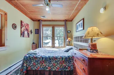 a bedroom with a bed and a window at Huge Waterfront Home with Dock on Lake Wallenpaupack in Hawley