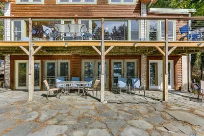 a deck with a table and chairs on a house at Huge Waterfront Home with Dock on Lake Wallenpaupack in Hawley