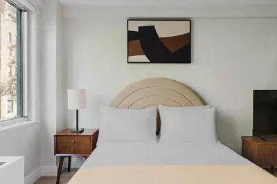 a bedroom with a white bed and a window at Blueground Midtown East fitness center nr UN NYC-2172 in New York