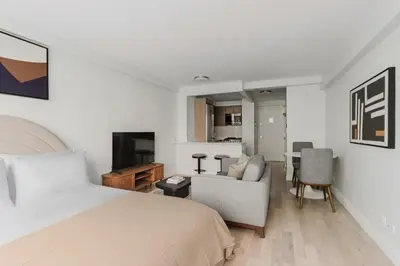 a bedroom with a bed and a living room at Blueground Midtown East fitness center nr UN NYC-2172 in New York