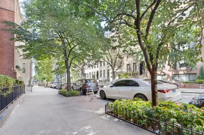 a sidewalk with cars parked on a street with trees at Blueground Midtown East fitness center nr UN NYC-2172 in New York