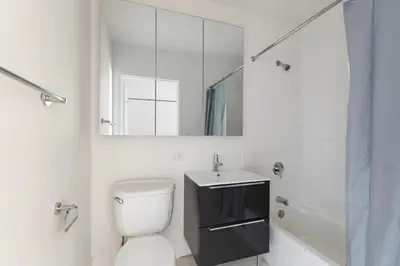 a bathroom with a toilet and a sink and a mirror at Blueground Financial District rooftop nr Brooklyn Bridge NYC-2201 in New York