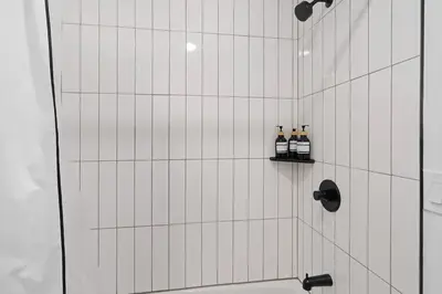 two bottles of wine sitting on a shelf in a shower at Spacious Duplex only 15 Minutes to NYC with Firepit Perfect for Groups in Jersey City