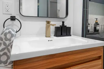 a white sink in a bathroom with a mirror at Spacious Duplex only 15 Minutes to NYC with Firepit Perfect for Groups in Jersey City