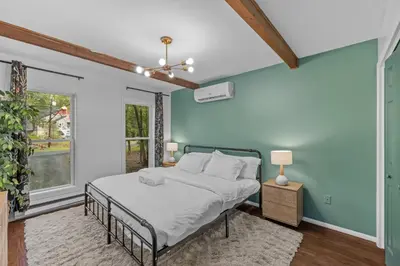 a bedroom with a bed and a blue wall at Pocono Serenity Retreat | 3-BR w/ Bonus King Suite & Hot Tub by Stay Lage in East Stroudsburg