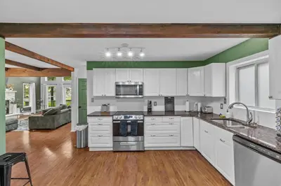 a kitchen with white cabinets and a stove top oven at Pocono Serenity Retreat | 3-BR w/ Bonus King Suite & Hot Tub by Stay Lage in East Stroudsburg