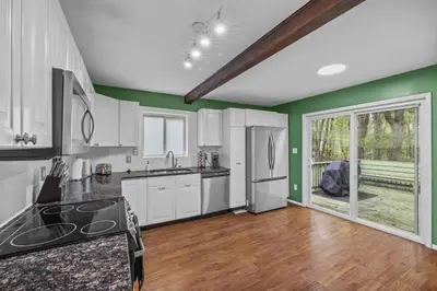 a kitchen with white cabinets and green walls at Pocono Serenity Retreat | 3-BR w/ Bonus King Suite & Hot Tub by Stay Lage in East Stroudsburg