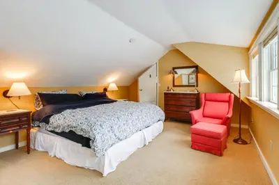 a bedroom with a bed and a red chair at Hike, Fish, Hunt! Green Mountain Home By River