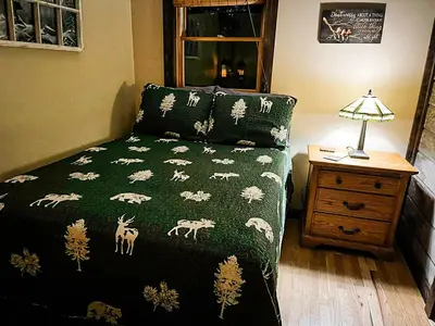 a bedroom with a bed with a green blanket with animals on it at Villa Gran Sasso in Hunter