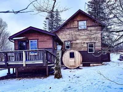 a log cabin in the snow with a wooden door at Villa Gran Sasso in Hunter