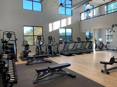 a gym with rows of exercise bikes and treadmills at Landing Apartments - The Preserve at Great Pond in Windsor