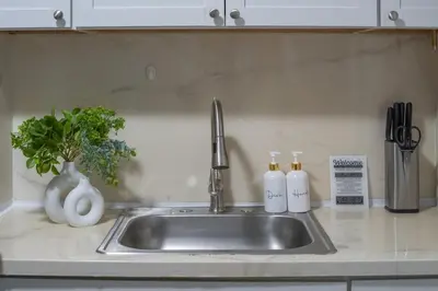 a kitchen sink with two soap bottles on it at Cozy Stay with Games, 15 min to NYC, Private Backyard - Sleeps 6 - NEAR METLIFE STADIUM in Jersey City