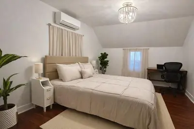 a bedroom with a large white bed and a desk at Cherry Blossom Lake House in Lake Peekskill