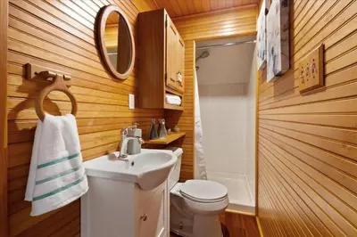 a bathroom with a white sink and a toilet at Cherry Blossom Lake House in Lake Peekskill