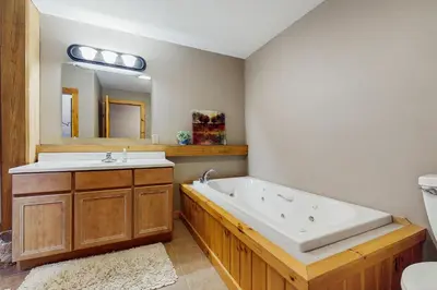 a bathroom with a tub and a sink and a mirror at Grouse Lane 12C in Dover