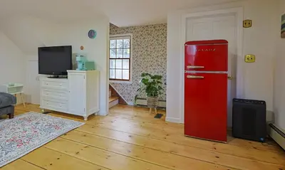 a red refrigerator in a room with a tv at Long Island Nature Retreat with Peloton with Shared Pool in Glen Head