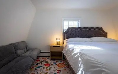 a bedroom with a bed and a couch at Long Island Nature Retreat with Peloton with Shared Pool in Glen Head