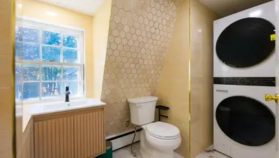 a bathroom with a toilet and a sink and a window at Long Island Nature Retreat with Peloton with Shared Pool in Glen Head