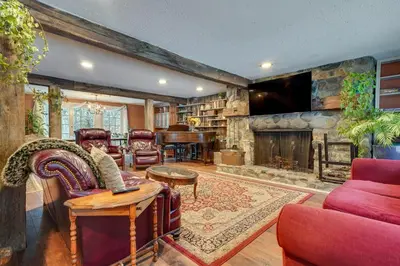 a living room with a stone fireplace and a tv at 3 Mi to Mount Snow Spacious West Dover Home in West Dover