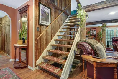 a wooden spiral staircase in a living room at 3 Mi to Mount Snow Spacious West Dover Home in West Dover