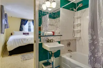 a bathroom with a sink and a bed and a tub at 3 Mi to Mount Snow Spacious West Dover Home in West Dover