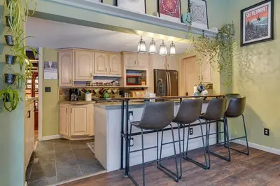 a kitchen with a bar with three chairs at it at 3 Mi to Mount Snow Spacious West Dover Home in West Dover